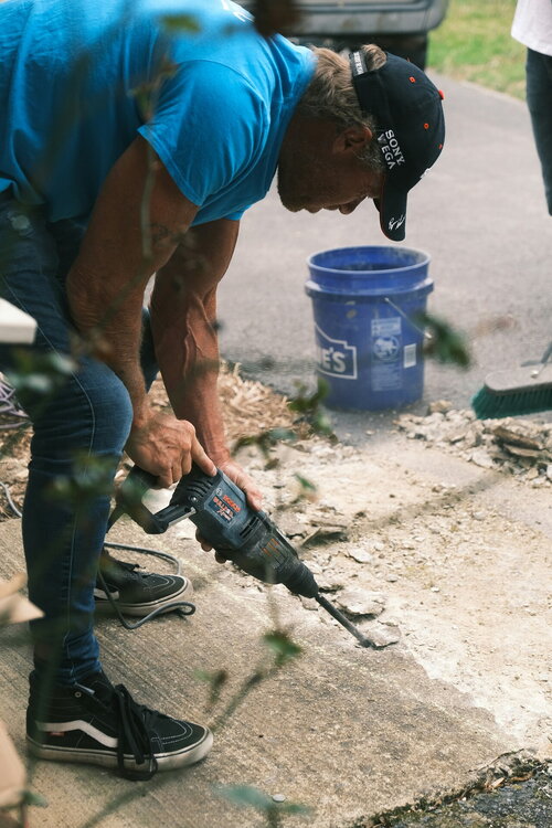 Persoon die beton wegneemt om de tuin te ontharden